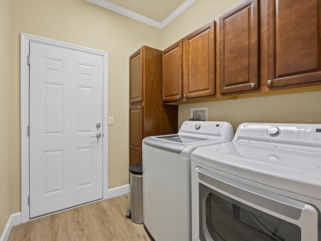 washroom with cabinets, ornamental molding, washer and clothes dryer, and light wood-type flooring