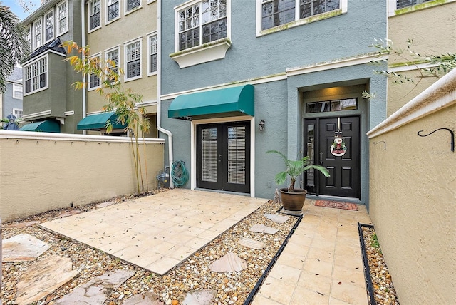 property entrance featuring french doors and a patio area