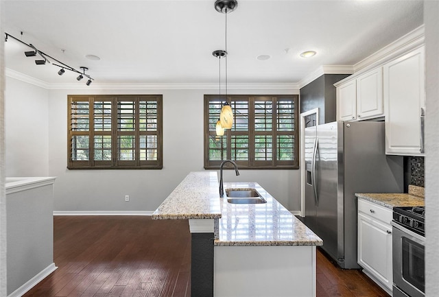 kitchen with sink, decorative light fixtures, appliances with stainless steel finishes, an island with sink, and white cabinets