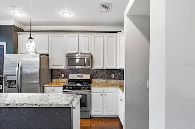 kitchen featuring stainless steel appliances, light stone countertops, hanging light fixtures, and white cabinets