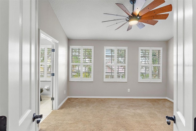 carpeted spare room with ceiling fan and a textured ceiling