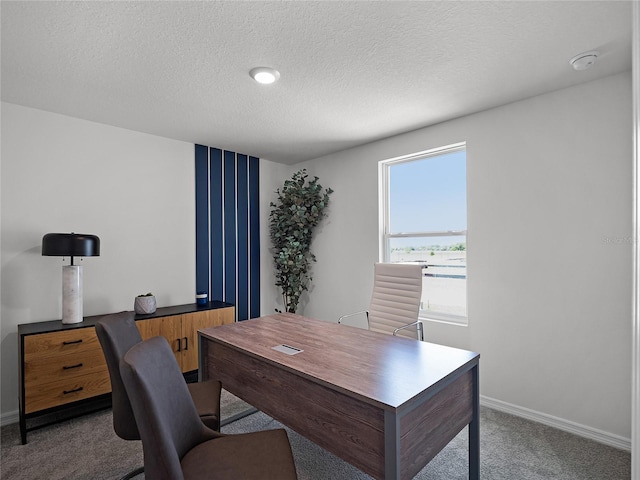 carpeted office space featuring a textured ceiling