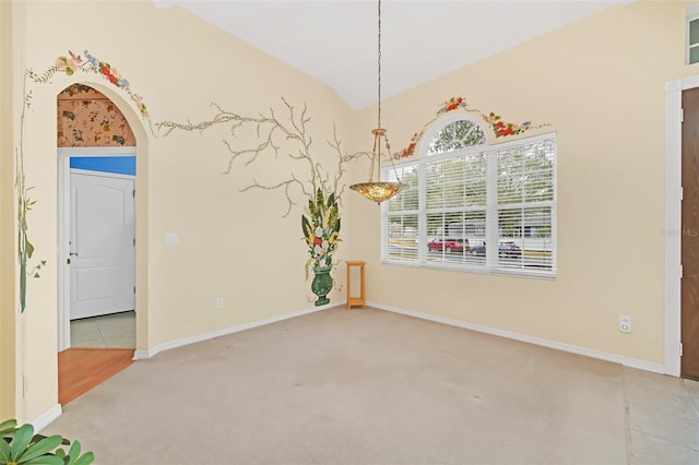 unfurnished dining area featuring light carpet and vaulted ceiling