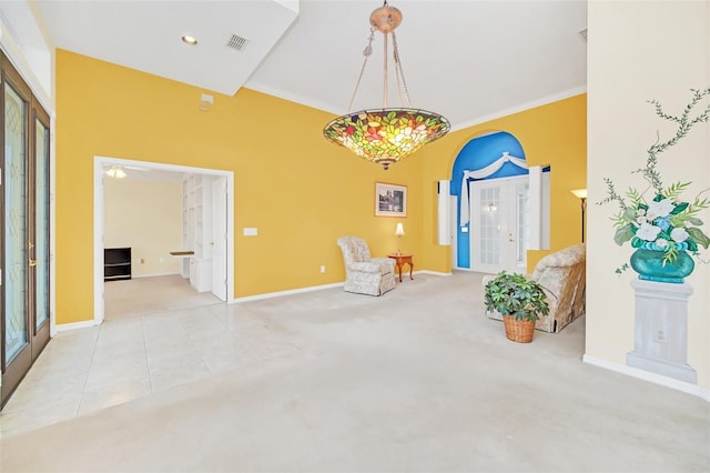 living area with french doors, light colored carpet, and ornamental molding