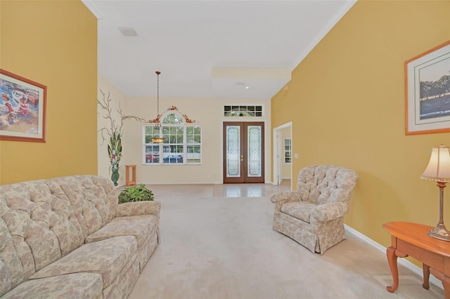 carpeted living room featuring ornamental molding and french doors