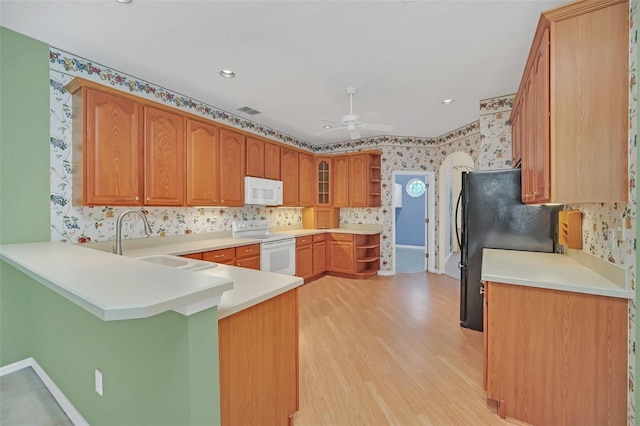 kitchen with sink, white appliances, ceiling fan, kitchen peninsula, and light wood-type flooring