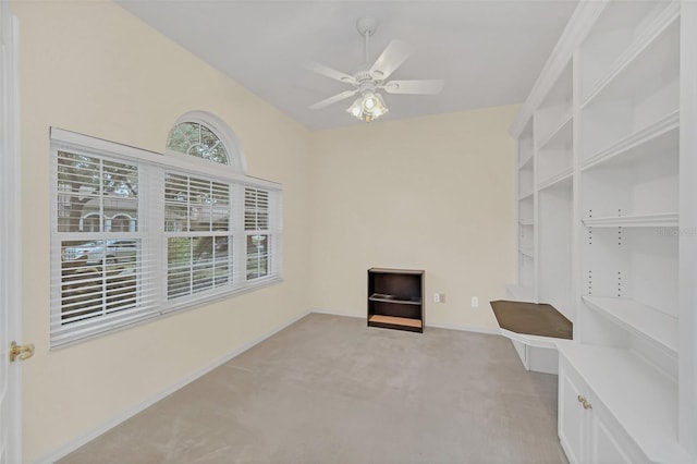 interior space with light carpet and ceiling fan