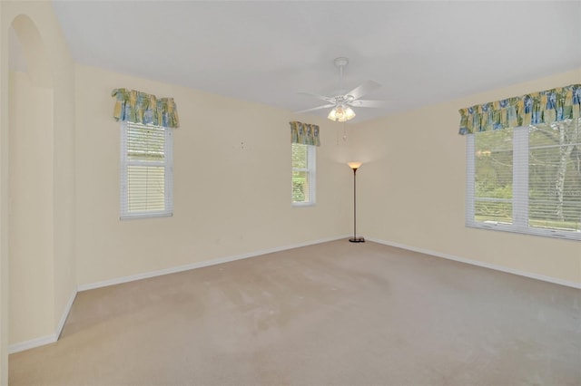 spare room featuring light colored carpet and ceiling fan