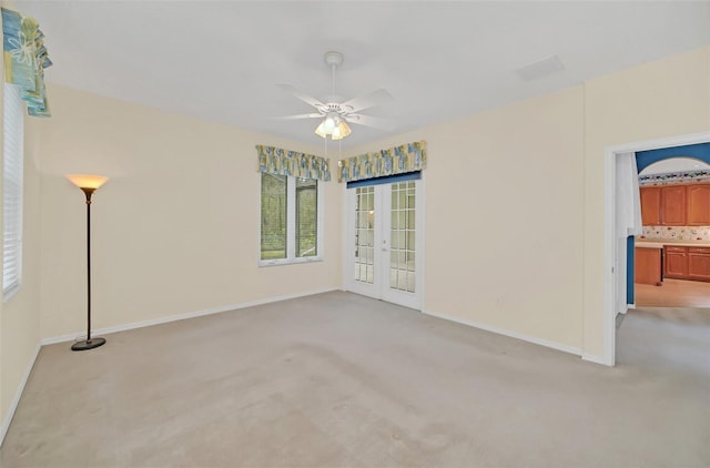 empty room featuring light carpet, french doors, and ceiling fan