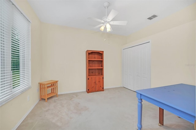 miscellaneous room with ceiling fan and light carpet