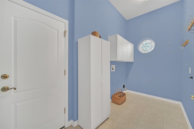 clothes washing area featuring a textured ceiling and light tile patterned floors