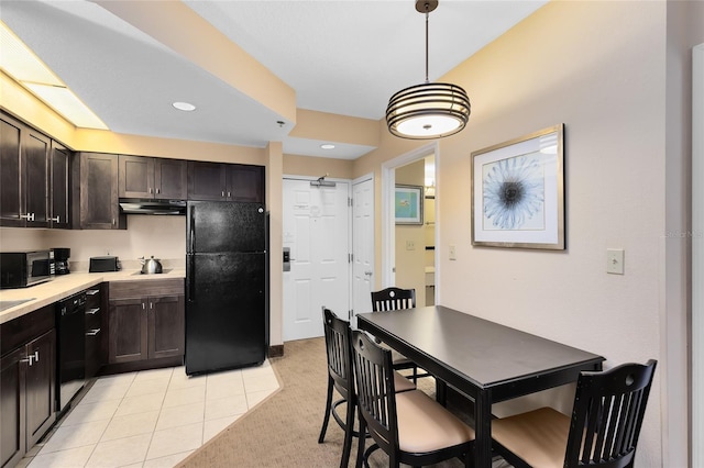 kitchen with light tile patterned flooring, black appliances, dark brown cabinets, and hanging light fixtures