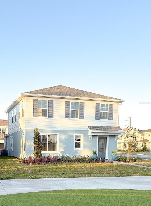 view of front of home with cooling unit and a front yard