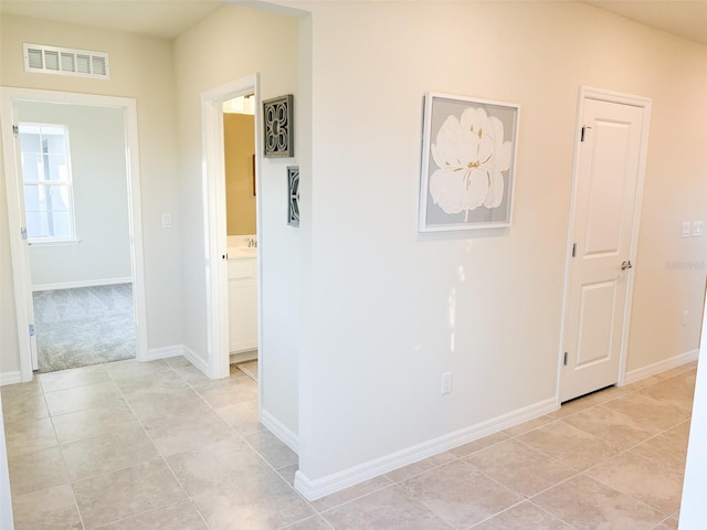 hallway featuring light colored carpet