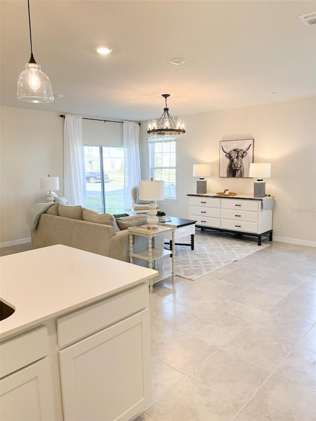 kitchen featuring white cabinetry, light tile patterned floors, a notable chandelier, and hanging light fixtures