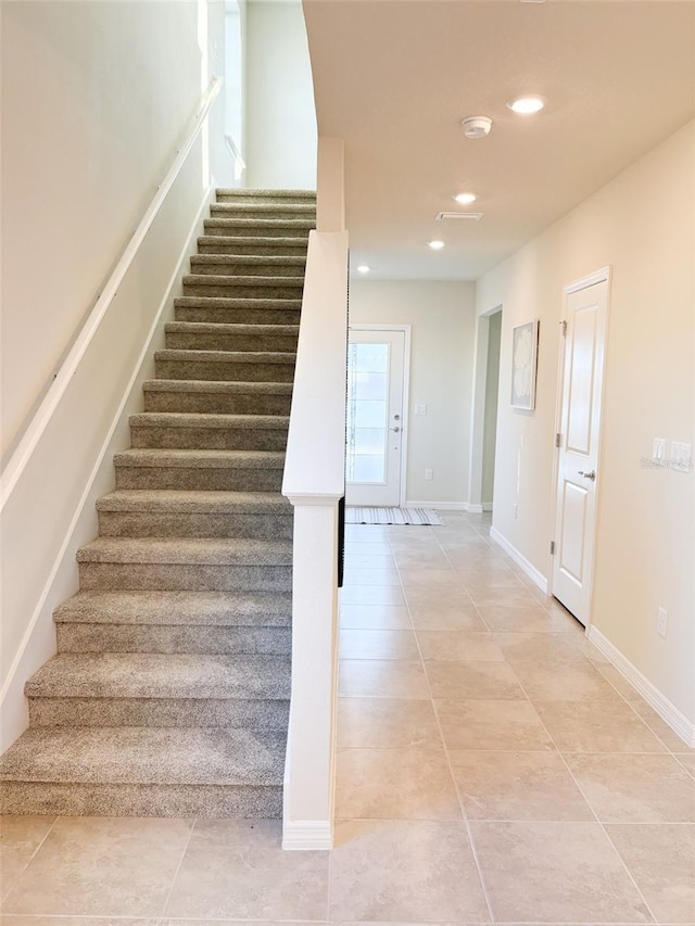 stairway featuring tile patterned flooring