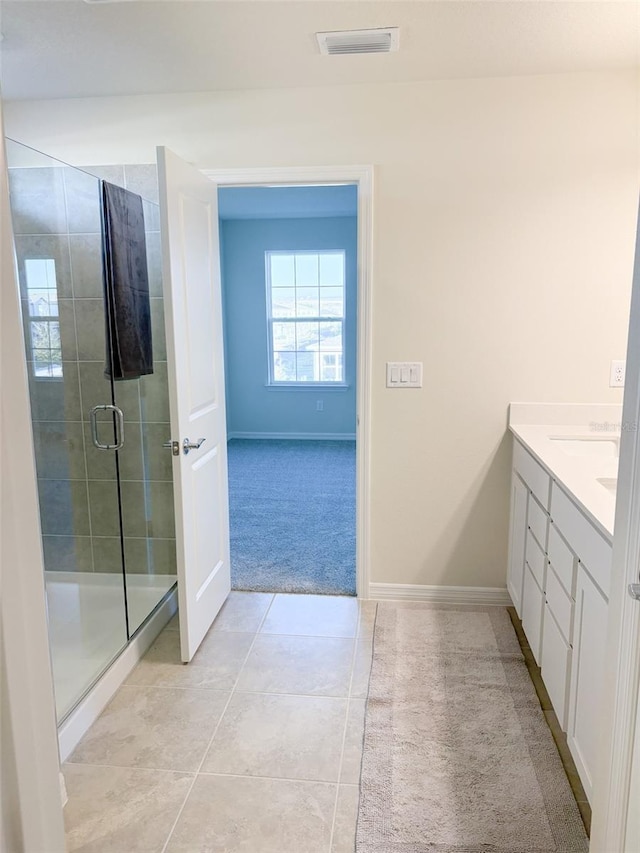 bathroom featuring walk in shower, vanity, and tile patterned flooring