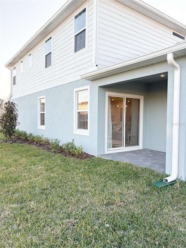 rear view of house featuring a yard and a patio