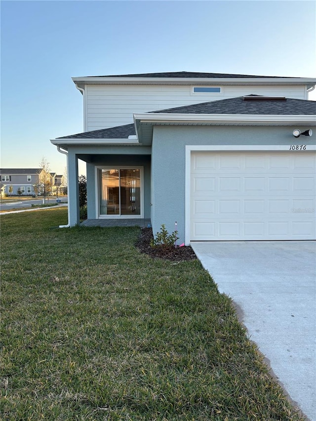 exterior space with a garage and a lawn