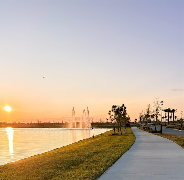 view of property's community with a water view and a yard