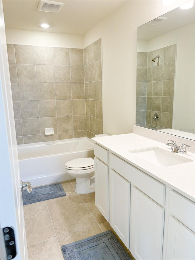 full bathroom with toilet, tile patterned flooring, tiled shower / bath, and vanity