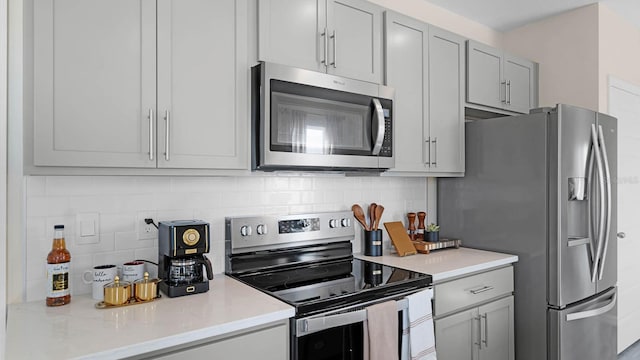 kitchen with light stone countertops, stainless steel appliances, and decorative backsplash