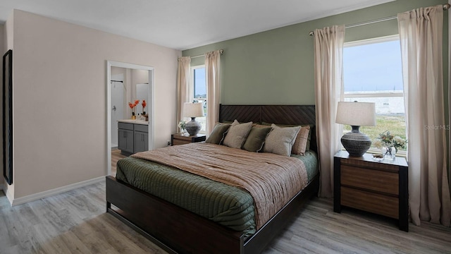 bedroom featuring ensuite bathroom and light hardwood / wood-style flooring