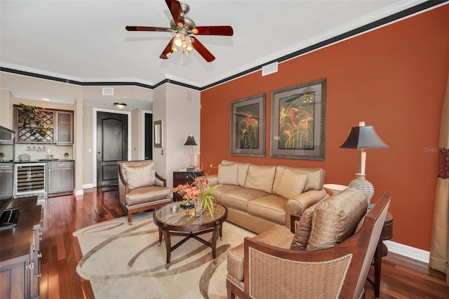 living room with ceiling fan, beverage cooler, ornamental molding, and hardwood / wood-style floors