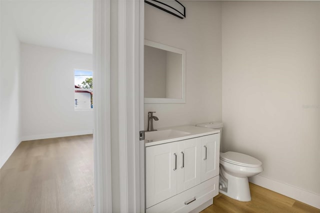 bathroom featuring toilet, vanity, and wood-type flooring