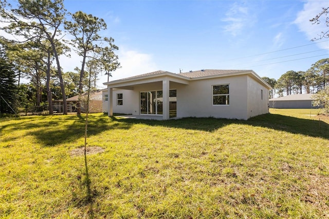 back of house with a lawn