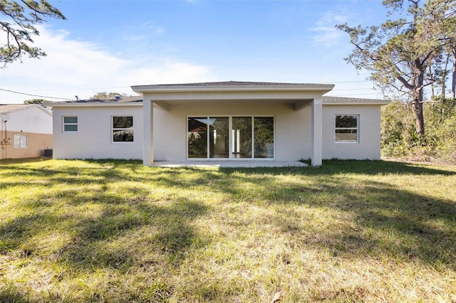 rear view of property featuring a lawn