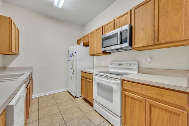 kitchen featuring sink, white appliances, and light tile patterned flooring