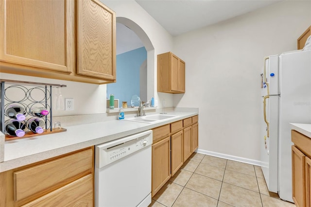 kitchen featuring light brown cabinetry, sink, white appliances, and light tile patterned floors