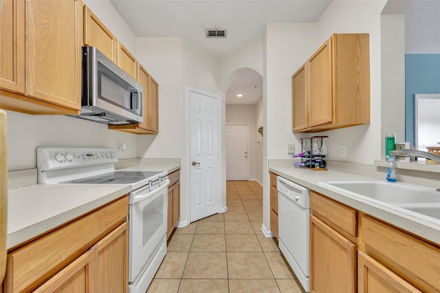 kitchen with sink, light brown cabinets, white appliances, and light tile patterned flooring