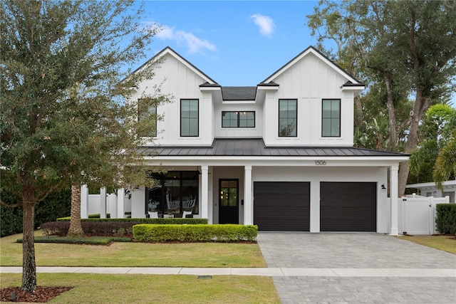 modern farmhouse with a front lawn and a garage