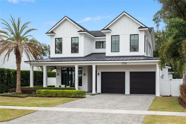 modern inspired farmhouse with a front yard, a garage, and a porch