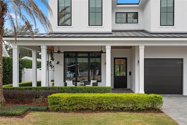 property entrance with a garage, ceiling fan, and a porch