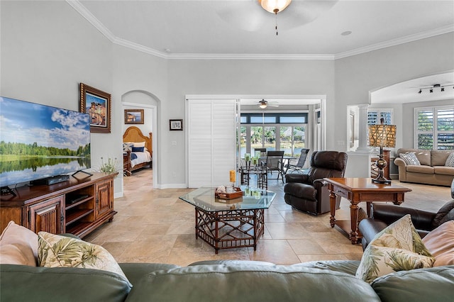 living room featuring ornamental molding, rail lighting, ceiling fan, and ornate columns