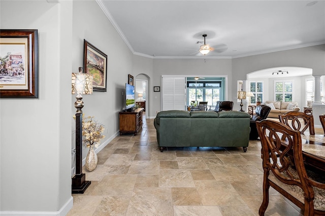 living room featuring crown molding, ceiling fan, and ornate columns