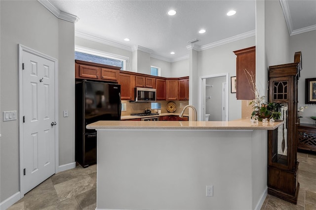 kitchen featuring sink, appliances with stainless steel finishes, tasteful backsplash, ornamental molding, and kitchen peninsula