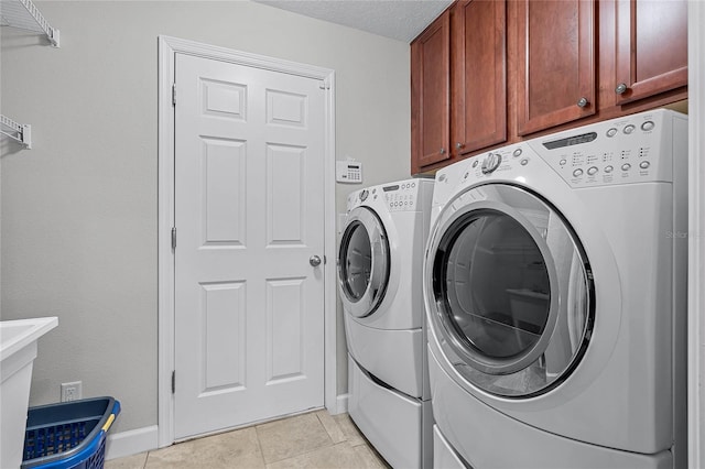 laundry room with cabinets, light tile patterned floors, independent washer and dryer, and a textured ceiling