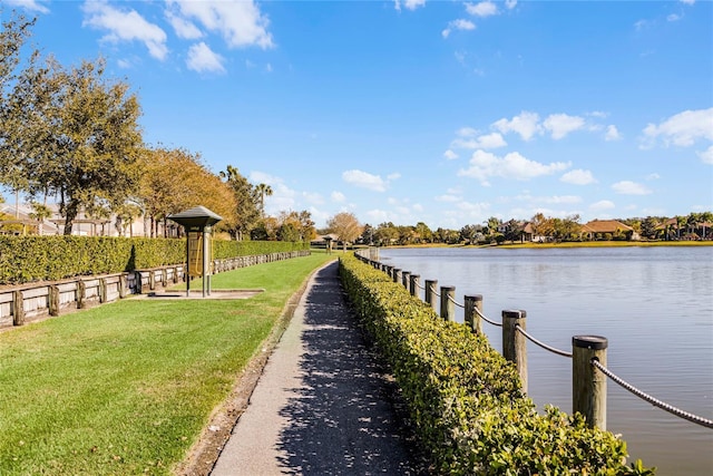 view of dock with a water view and a yard