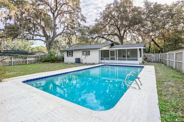 view of swimming pool with central AC, a yard, and a sunroom