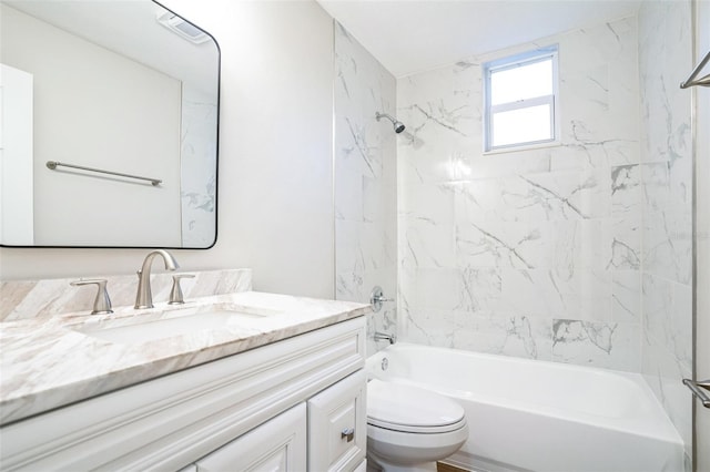 full bathroom featuring vanity, tiled shower / bath combo, and toilet