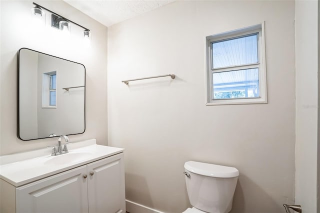 bathroom featuring a textured ceiling, vanity, and toilet