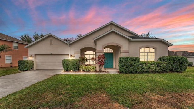 view of front of home with a garage and a lawn