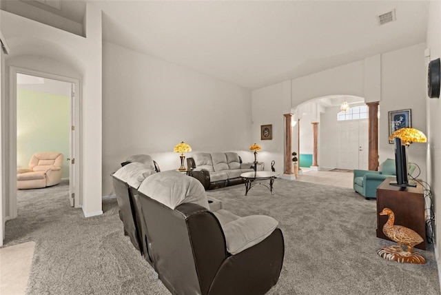 carpeted living room with decorative columns