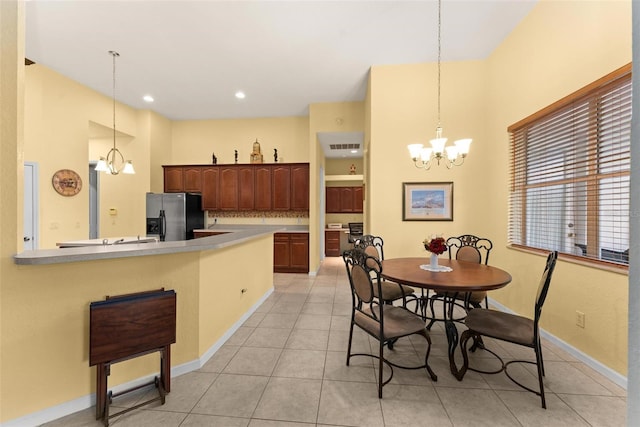 dining space featuring light tile patterned floors and an inviting chandelier