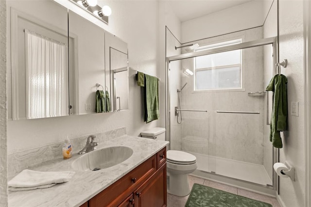 bathroom with toilet, vanity, tile patterned flooring, and walk in shower