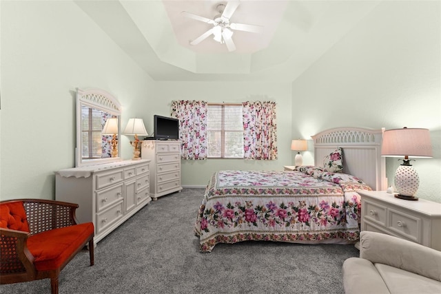 carpeted bedroom featuring ceiling fan and a tray ceiling